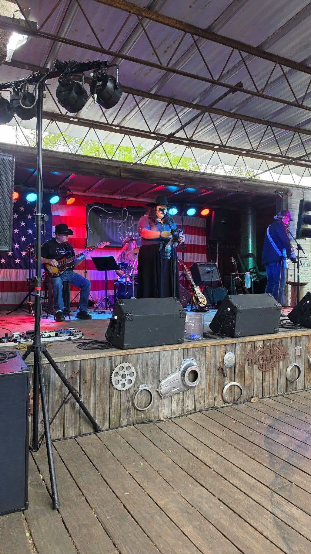 Vocalist performing under stage lights with American flag backdrop